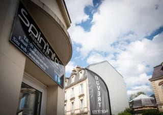 Enseigne « Spin’info, atelier informatique » et oriflamme « Ouvert » sur la façade de la boutique, au bord de la rue.