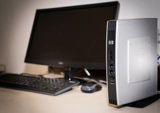 Un mini-ordinateur de bureau installé à côté d’un écran, d’un clavier et d’une souris.