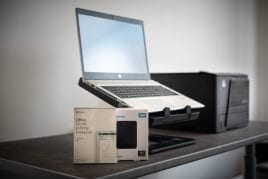 Un ordinateur portable neuf présenté avec une suite bureautique et un disque de sauvegarde.