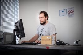 Un technicien à son poste, au clavier devant un écran.